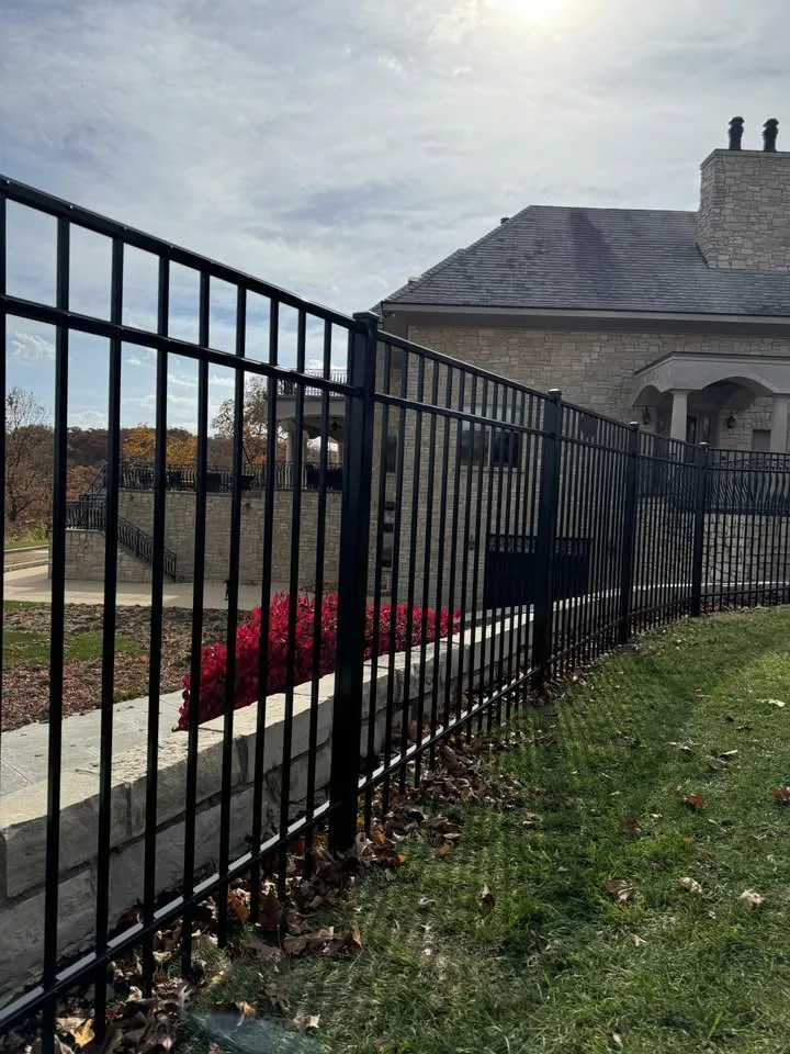 Black ornamental aluminum fence on a stone retaining wall at a Central Illinois estate