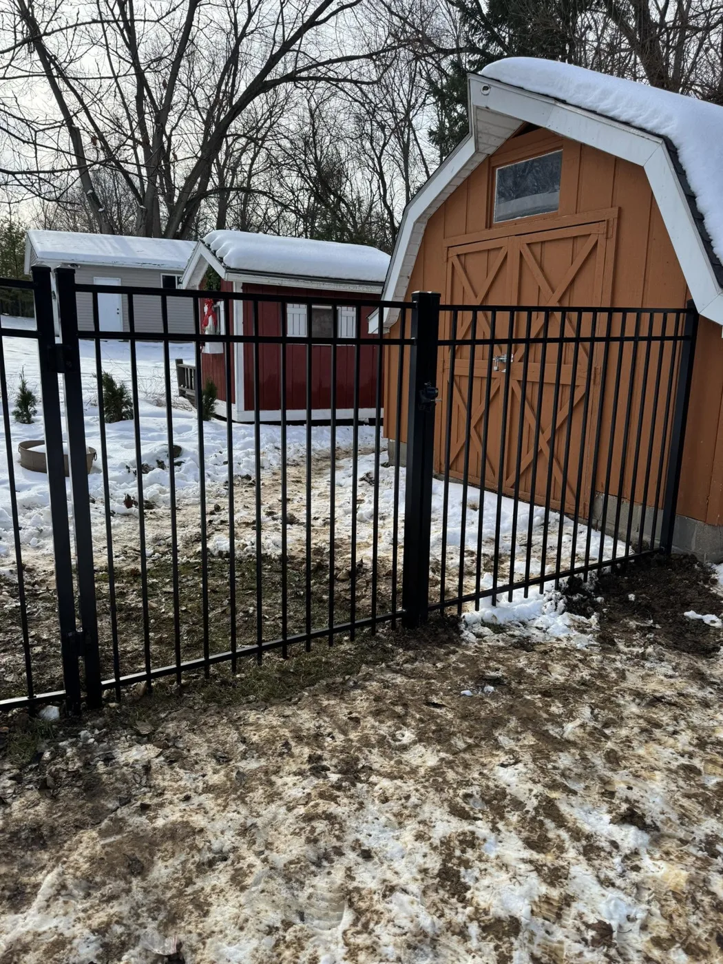 Black aluminum fence beside a shed in snowy Central Illinois