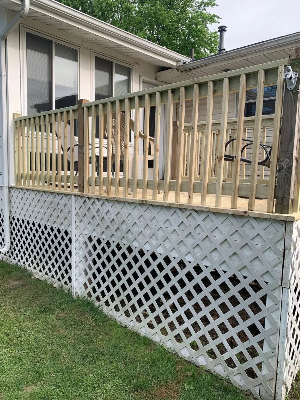 Elevated deck with white lattice skirting and wood railing in Central Illinois