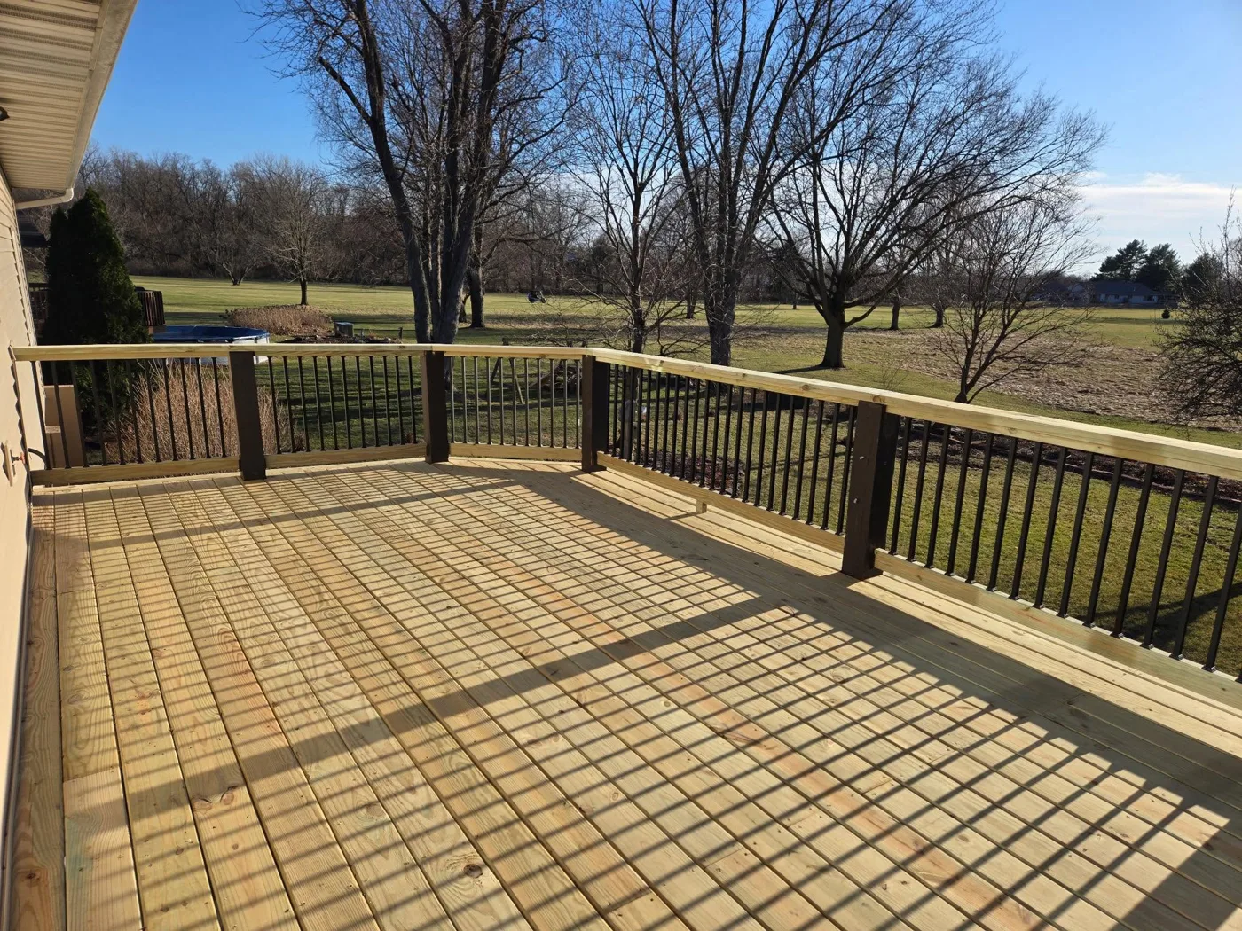 Large new wood deck with railing overlooking countryside in Central Illinois
