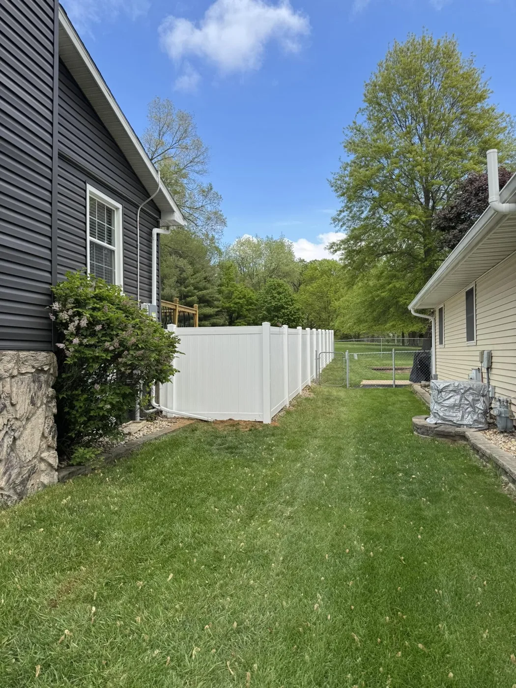 White vinyl privacy fence enclosing a large lawn in Central Illinois