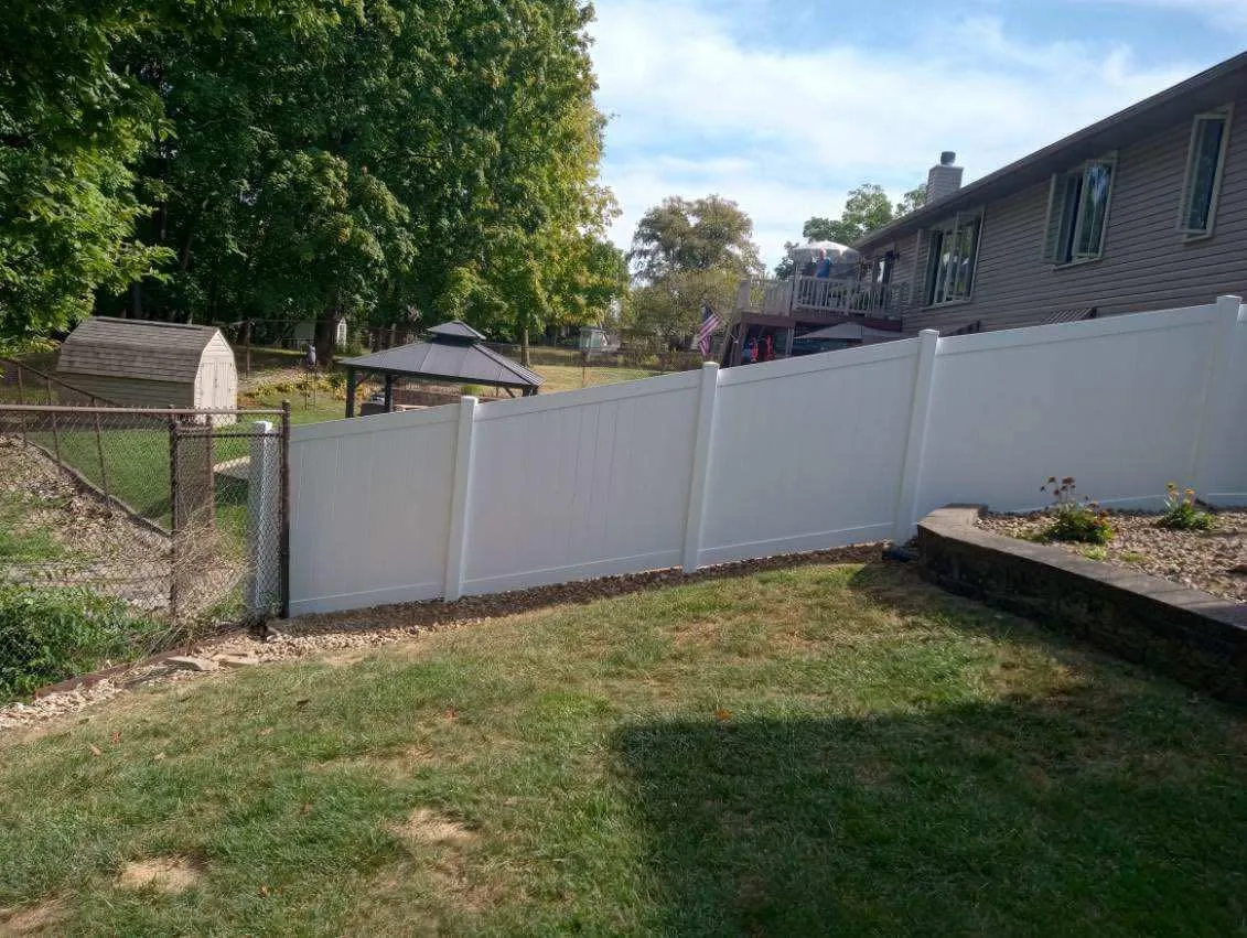 White vinyl privacy fence along a green backyard in Peoria, Illinois