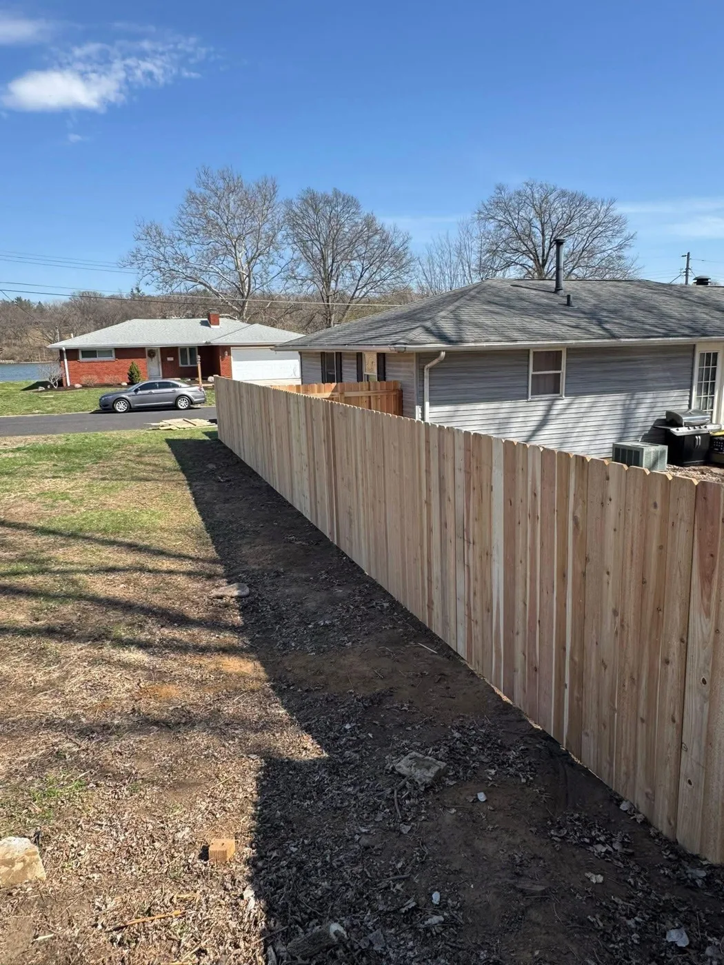 Long wood privacy fence line installed along a property boundary in Central Illinois